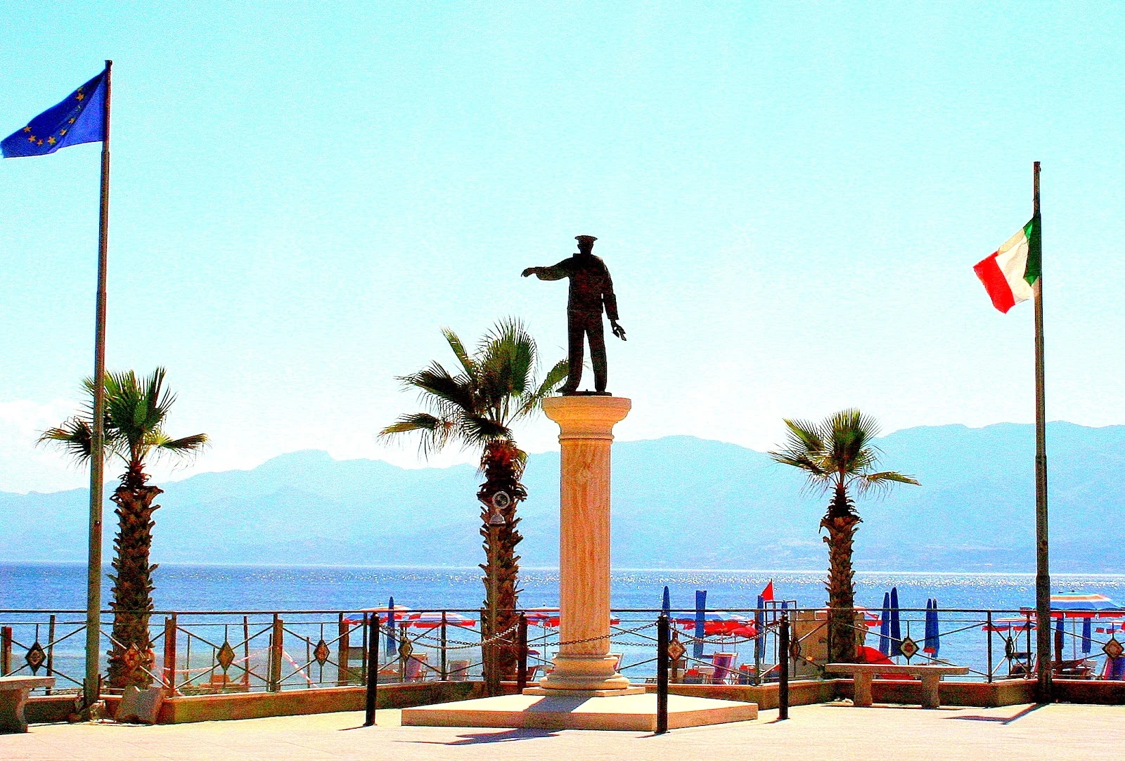 Il Monumento al Marinaio sul lungomare di Catona, con le bandiere europea e italiana e lo Stretto sullo sfondo